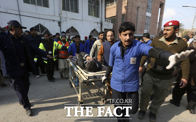 30일(현지시간) 파키스탄 페샤와르의 한 이슬람 사원과 경찰서 부근에서 자살폭탄 테러가 발생한 가운데 의료진이 부상당한 피해자를 옮기고 있다. /페샤와르=AP.뉴시스