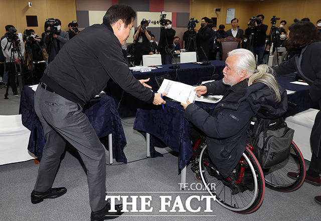 오세훈 서울시장이 2일 오후 서울 중구 서울특별시청에서 박경석 전국장애인차별철폐연대 대표와 면담을 하며 자료를 받고 있다. /이동률 기자