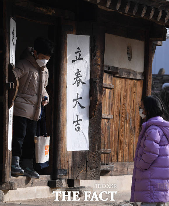 어린이들이 박물관 내 전통한옥 대문에 붙은 입춘첩이 붙은 전통한옥 문을 지나고 있다.