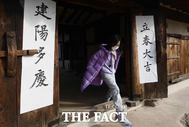 서울 종로구 국립민속박물관을 찾은 어린이가 입춘첩이 붙은 전통한옥 대문을 지나고 있다.