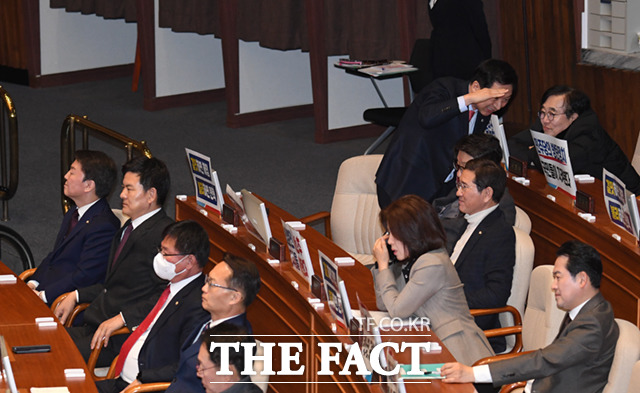 국민의힘 당권주자인 김기현 의원(오른쪽)이 본회의에 참석하며 의원들과 인사를 나누고 있다.