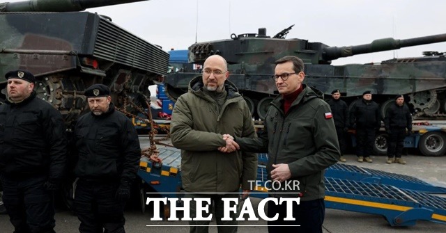 데니스 슈미갈(Denys Schmyghal) 우크라이나 총리(왼쪽)와 마테우시 모라비에츠키 폴란드 총리가 폴란드가 인도한 레오파르트2A4 탱크 앞에서 악수하고 있다. /데니스 슈미칼 총리 트위터