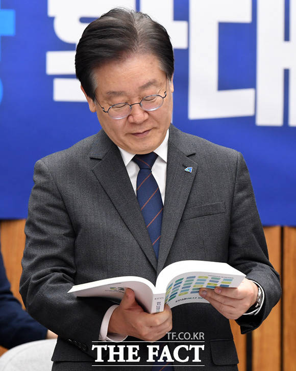 이재명 더불어민주당 대표가 6일 서울 여의도 국회에서 열린 확대간부회의에 앞서 박주민 을지로위원장으로부터 받은 을지로위원회 백서를 살펴보고 있다.
