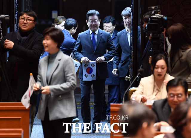 이재명 더불어민주당 대표가 16일 서울 여의도 국회에서 열린 의원총회에 참석, 태극기를 든 채 의총장에 입장하고 있다.