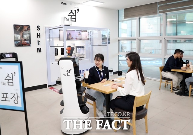 대전 유성구청 직원들이 구청 1층 ‘로봇 카페 더 쉼’에서 로봇이 서빙한 음료를 받고 있다. / 유성구