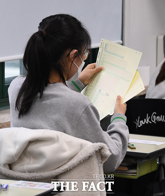 학생들이 시험에 앞서 답안지를 받고 있다.