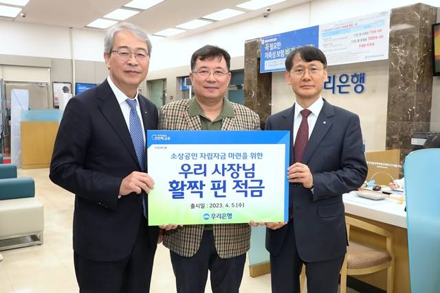 우리금융그룹 임종룡 회장(왼쪽)과 우리은행 정연기 중소기업그룹 부행장(오른쪽)이 소상공인 상생금융상품 우리 사장님 활짝 핀 적금 1호 가입 고객과 기념촬영을 하고 있다. /우리금융