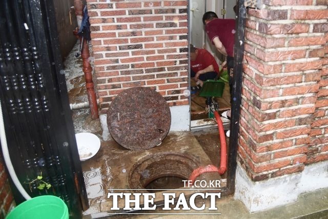 SH가 서울 반지하 주택 3450가구를 매입한다. 서울 신림동의 한 반지하 주택에서 주민들이 집으로 들어찬 물을 퍼내고 있다. /더팩트DB