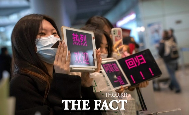 마스크를 쓴 마중객들이 지난 15일 중국 베이징 국제공항 국제선 입국장에서 환영 문구가 쓰인 태블릿 PC를 들고 있다. / AP=뉴시스