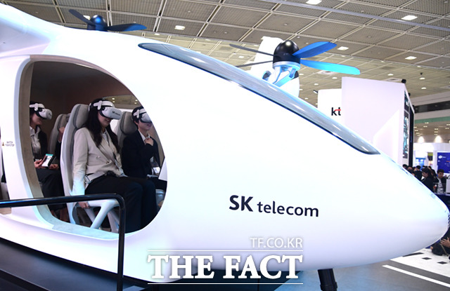 19일 서울 강남구 삼성동 코엑스에서 열린2023 월드 IT쇼에서  관람객들이 SK텔레콤의 도심항공교통(UAM) 체험을 하고 있다.