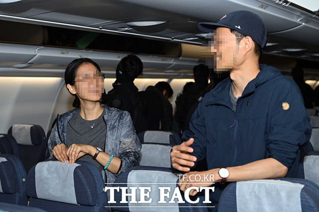 한국행 비행기 탑승 뒤 미소 짓는 국민들.