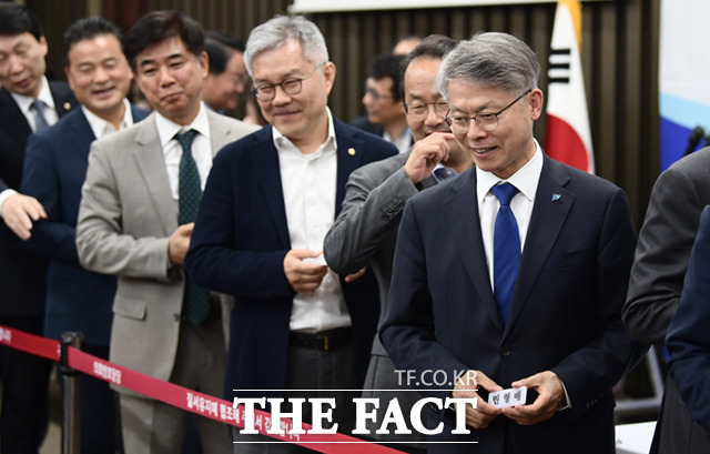 민형배 의원이 28일 서울 여의도 국회에서 열린 제21대 국회 더불어민주당 제4기 원내대표 선출을 위한 의원총회에 참석, 투표를 위해 명패를 든 채 기표소로 향하고 있다.