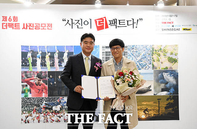 한국사진기자협회 특별상을 수상한 김영수 씨 대리수상자(오른쪽)가 이호재 한국사진기자협회 협회장과 기념촬영을 하고 있다.