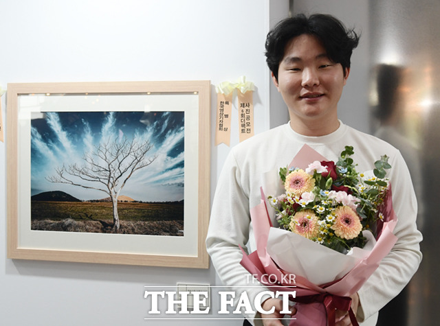 한국영상기자협회 특별상 수상자인 황재순 씨가 작품과 함께 기념촬영하고 있다.