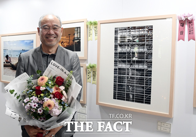 제6회 더팩트 사진 공모전 대상 수상자 황재순 씨가 작품과 함께 기념촬영하고 있다.