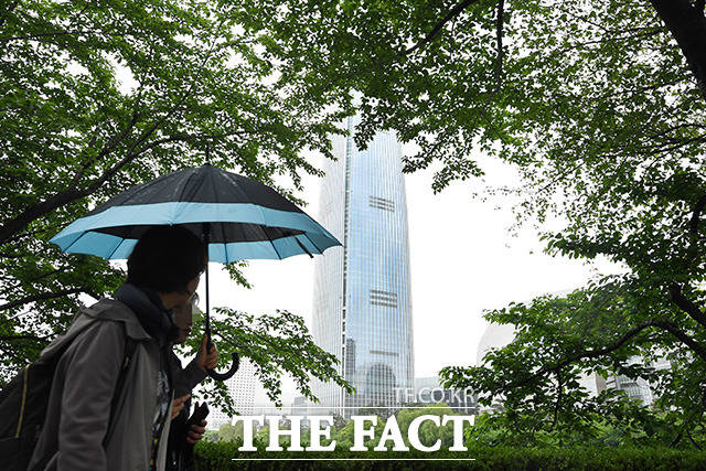 전국이 흐리고 강풍을 동반한 비가 내리고 있는 5일 오전 서울 송파구 석촌호수를 찾은 시민들이 우산을 쓴 채 산책을 하고 있다. /남용희 기자