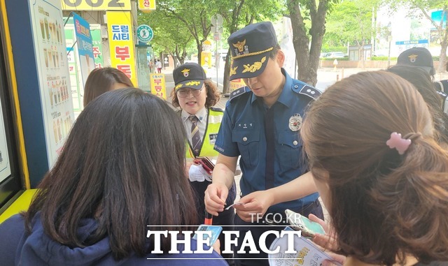 경찰이 시민들에게 GHB마약(통칭 물뽕) 검출 스티커 사용법을 설명하고 있다. /대구 성서경찰서