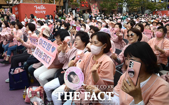 13일 오후 서울 마포구 홍대 일대에서 열린 레드로드 선포식에서 가수 이찬원이 축하 공연을 하는 가운데, 팬들이 응원을 펼치고 있다.