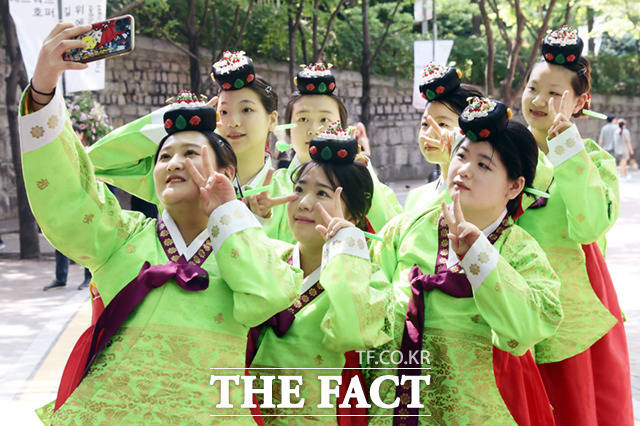 14일 제51회 성년의 날 기념행사가 서울 덕수궁 돌담길에서 열린 가운데, 전통 성년식 체험을 마친 만 19세가 되는 성년들이 셀프 사진을 찍고 있다.