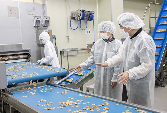 전라남도 여수에 있는 식품 기업 쿠키아에서 삼성전자 스마트공장 담당자(오른쪽)와 쿠키아 직원이 두부과자 품질 상태를 점검하고 있다. /삼성전자