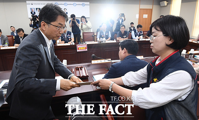박희은 위원이 박준식 위원장에게최저임금위 전원회의 모두공개 요구사항이 담긴 서류를 전달하고 있다.