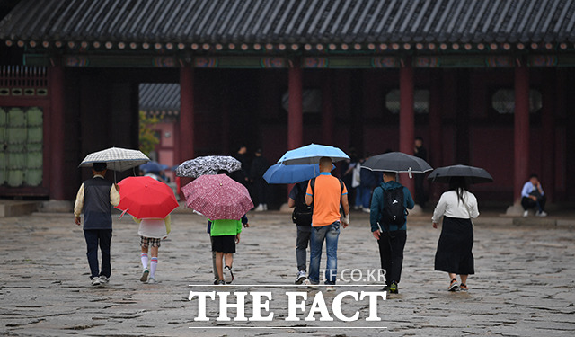 부처님오신날인 27일 오후 서울 종로구 경복궁을 찾은 관람객들이 우산을 쓰고 걷고 있다. /박헌우 기자