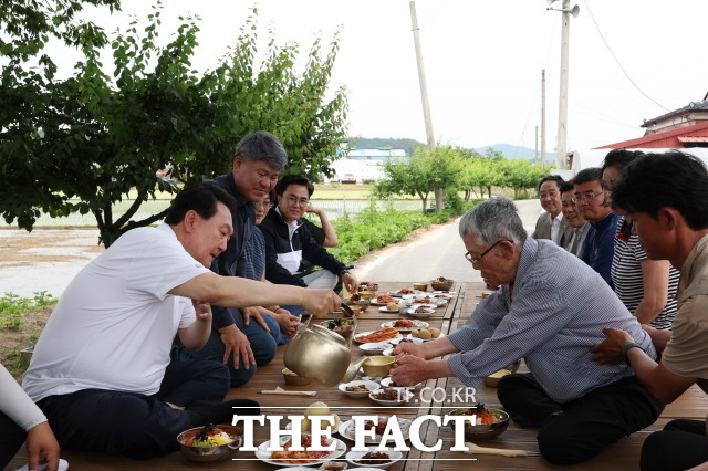 윤석열 대통령은 7일 충남 부여군 임천면 꿈에영농조합법인을 방문해 농업인을 격려했다. 이날 모내기를 마친 뒤 주민들과 새참을 먹고 있는 윤 대통령. /대통령실 제공