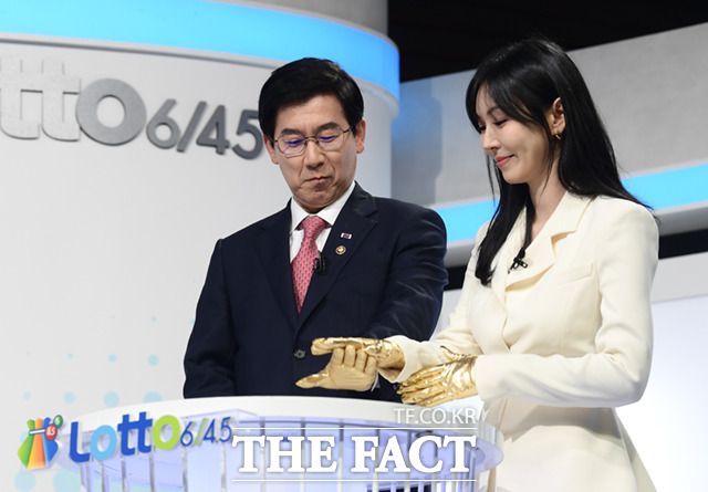 최 차관(왼쪽)과 김소연이 황금장갑을 낀 손으로 로또 버튼을 누르고 있다.