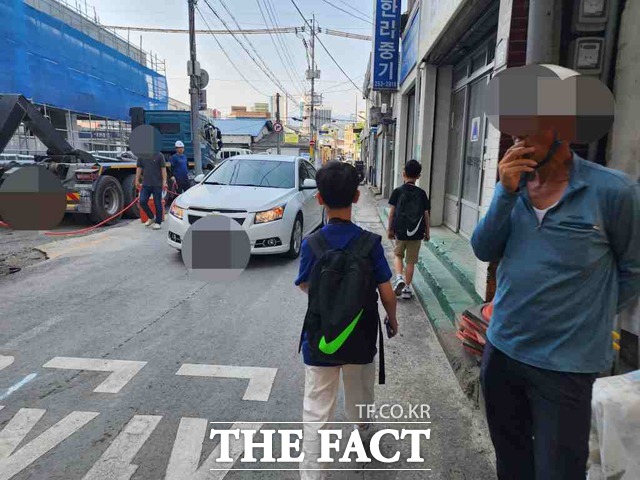 19일 오전 대구 수창조 통학시간에 현장 작업자가 학생이 옆을 지나가는 데도 담배를 피고 있다. / 대구 = 박성원 기자