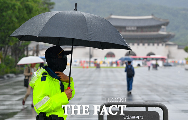 전국적으로 장마 영향권에 들어간 가운데 잠시 소강상태를 보이는 26일 오전 서울 종로구 광화문 광장에서 경찰이 우산을 쓰고 보초근무를 서고 있다. /장윤석 인턴기자