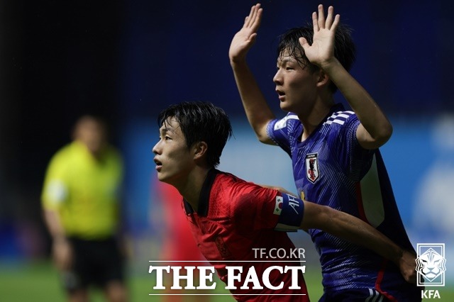 한국 스트라이커 김명준(왼쪽)이 일본 선수와 볼을 다투고 위해 자리 경합을 벌이고 있다./빠툼타니=KFA