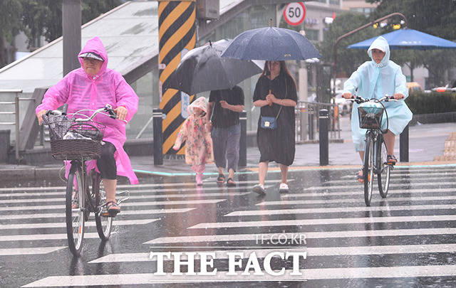 중부·전라·경북 북부내륙을 중심으로 시간당 30~60㎜의 강한 비가 내리고 있다. 호우주의보가 발효된 4일 오후 서울 은평구 불광역 일대의 시민들이 우비를 쓰고 자전거를 타고 있다. /장윤석 인턴기자