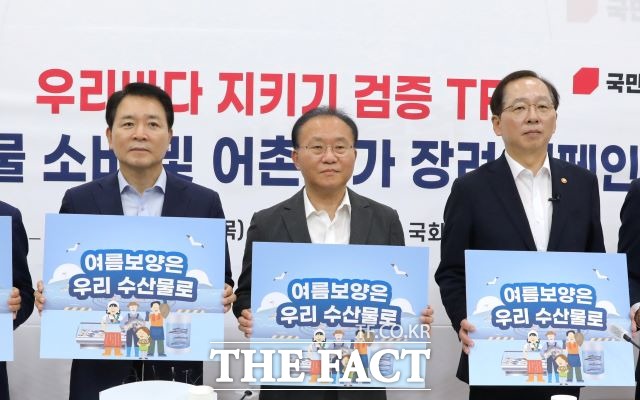 윤재옥 국민의힘 원내대표와 참석자들이 27일 오후 서울 여의도 국회에서 열린 우리바다 지키기 검증 TF 주최 수산물 소비 및 어촌휴가 장려 캠페인에서 여름보양은 우리 수산물로라고 적힌 피켓을 들고 있다. /뉴시스