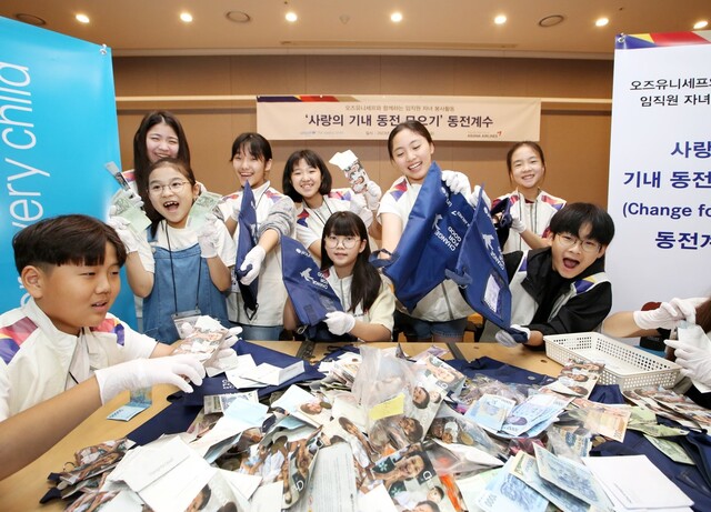 아시아나항공 임직원 자녀들이 28일 사랑의 기내 동전 모으기 캠페인으로 모인 동전의 계수 봉사활동에 참여해 동전을 분류하고 있다. /아시아나항공