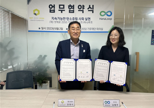 김혜연(오른쪽) 하나루프 대표와 장대식 넷제로 2050 기후재단 이사장이 업무협약 체결 후 협약서를 펼쳐 보이고 있다. /하나루프