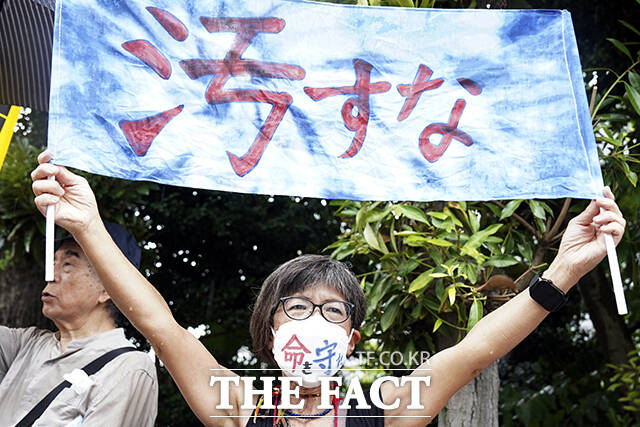 24일 일본 도쿄의 도쿄전력 본사 앞에서 오염수 방류를 규탄하는 시위하고 있다. 일본 정부와 도쿄전력은 24일 오후 1시부터 후쿠시마 제1원자력발전소 오염수의 해양 방류를 시작한다. /도쿄=AP.뉴시스