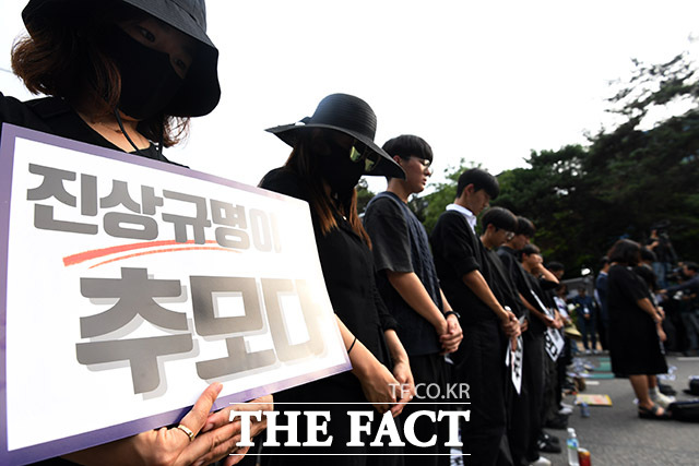 서이초 교사의 49재이자 공교육 멈춤의 날인 4일 오후 서울 여의도 국회 앞에서 열린 서이초 교사 49재 추모 집회에서 참가자들이 손피켓을 들어보이며 묵념을 하고 있다. /남용희 기자