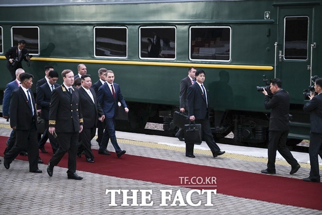 김정은 북한 국무위원장이 12일 전용열차를 타고 러시아 연해주 남단 하산스키 하산역에 도착, 환영식을 받으며 알렉산드르 코즐로프 러시아 천연자원생태부 장관과 함께 걸어가고 있다. /하산(러시아)=AP/뉴시스