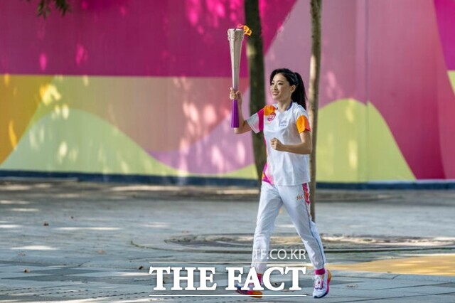 2004 아테네올림픽 100m 평영 금메달리스트인 뤄쉐쥐안(罗雪娟)이 지난 8일 중국 저장성 항저우에서 열린 제19회 항저우 아시안게임 성화 봉송 첫 주자로서 햇불을 들고 달리고 있다. 그는 항저우시 출신이다. / 신화.뉴시스