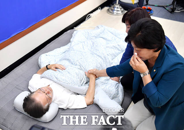 15일째 단식투쟁을 이어가고 있는 이재명 더불어민주당 대표가 14일 오후 서울 여의도 국회 당 대표회의실에서 눈물 흘리는 남인순 의원의 손을 잡고 있다.