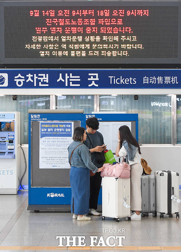 서울역에서 열차를 기다리는 여행객들 위로 열차 운행 중지를 알리는 전광판이 보이고 있다.