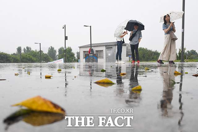 전국 대부분 지역에서 강한 비가 계속되는 가운데 20일 오전 서울 영등포구 여의도 한강공원을 찾은 시민들이 우산을 쓰고 있다. /장윤석 인턴기자