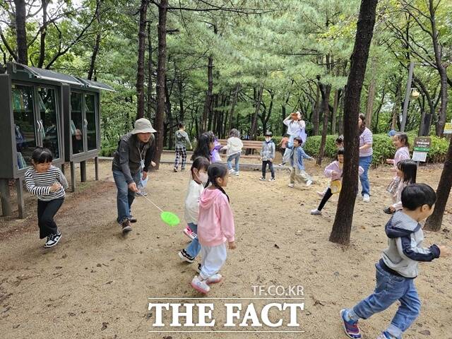 27일 오전 성북구 개운산근린공원 유아숲체험원에서 아이들이 유아숲지도사와 뛰어노는 모습. /성북구