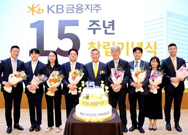 윤종규 KB금융그룹 회장이 27일 서울 여의도 KB국민은행 본점 신관에서 열린 창립 15주년 기념식에서 장기 근속 직원들과 함께 기념촬영을 하고 있다. /KB금융