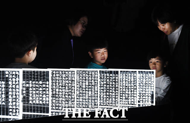 제577돌 한글날인 9일 오전 서울 용산구 국립한글박물관을 찾은 어린이들이 빛으로 형상화한 훈민정음 해례본을 살펴보고 있다. /이새롬 기자