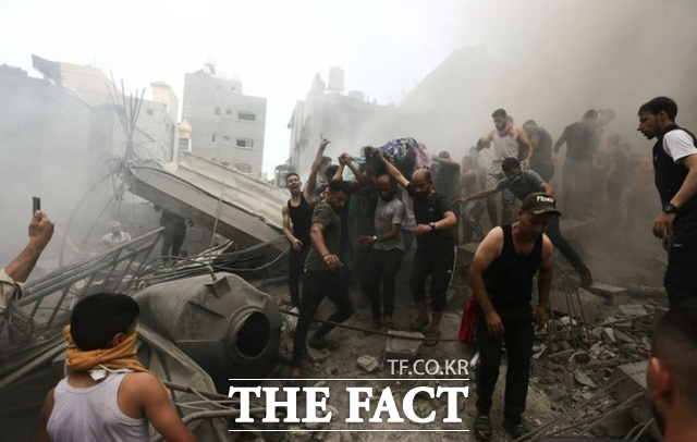 9일(현지시각) 가자지구 팔레스타인 주민들이 이스라엘의 공격으로 파괴된 건물 잔해에서 희생자 시신을 수습하고 있다. /가자지구=AP/뉴시스