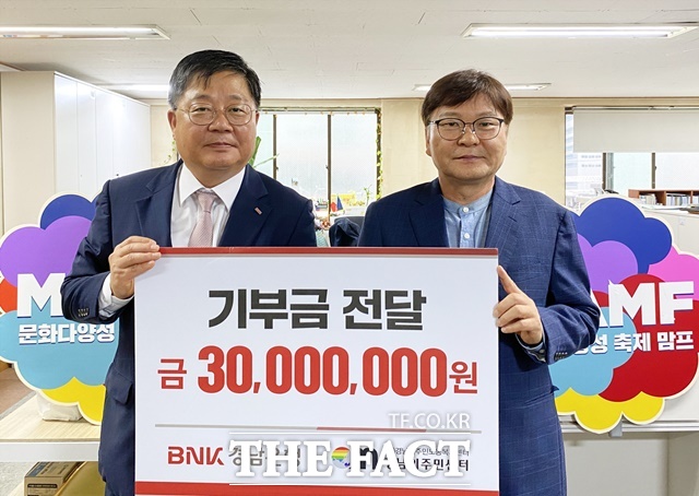 박상호 BNK경남은행 상무(왼쪽)가 이철승 경남이주민노동복지센터 대표에게 기부금 3000만원 기탁 증서를 전달하고 있다./경남은행