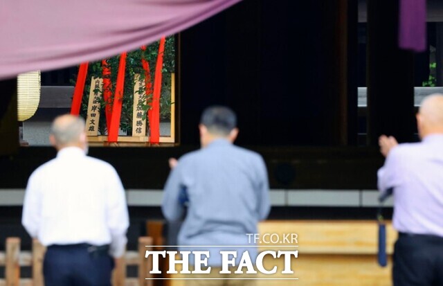 일본 시민들이 지난해 추계 대예제 기간이었던 10월 17일 일본 도쿄의 야스쿠니 신사에서 기시다 후미오 총리가 봉납한 공물(왼쪽)이 놓인 제단에 참배하고 있다. /AP.뉴시스
