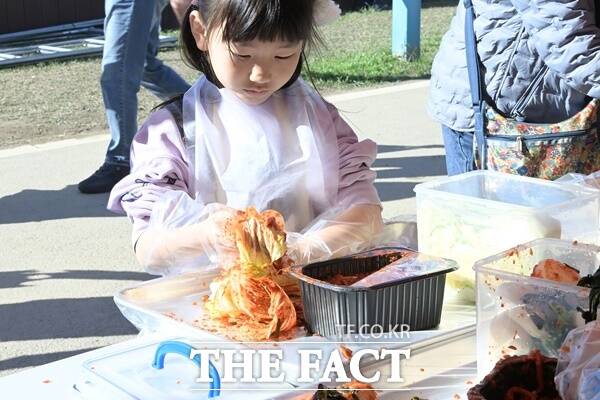 어린이가 젓갈 김치 담그기 행사에 참여해 김치 담그고 있다./논산시