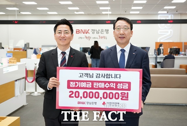 신태수 BNK경남은행 부행장(오른쪽)이 경남사회복지공동모금회 박은덕 사무처장에게 성금 기탁 증서를 전달하고 있다./경남은행